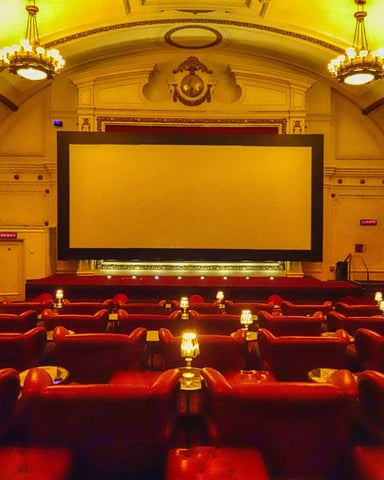Ornate vintage cinema hall with red leather seats